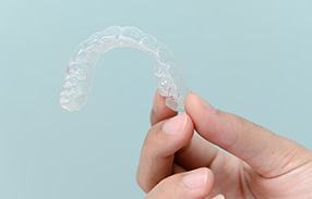 Closeup of patient holding clear aligner