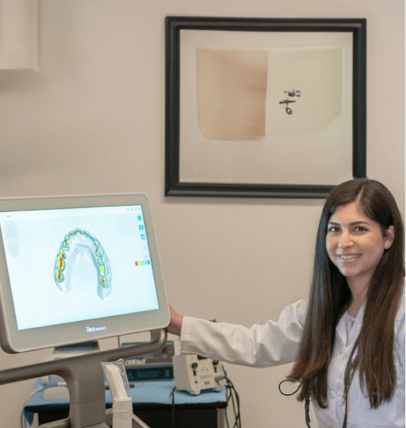 Doctor Saber showing a patient digital scans of their teeth on computer monitor